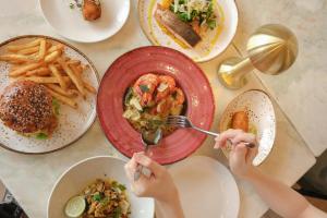 a table topped with plates of food and french fries at AMI Suites in Kuala Lumpur