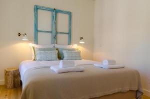 1 dormitorio con 1 cama grande y 2 toallas. en Casas d'Mouraria, en Lisboa