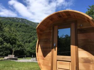 a wooden door of a building with a mountain in the background at Le Milan pour 10 et son bain nordique privatif in Camous