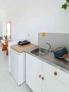 a white kitchen with a sink and a counter at Lecini Studios in Laganas