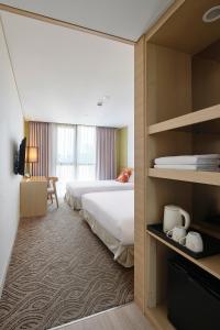 Ένα ή περισσότερα κρεβάτια σε δωμάτιο στο Jeju Central City Hotel