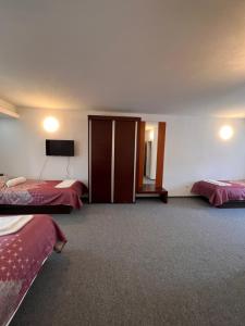 a hotel room with two beds and a flat screen tv at Hotel Begić in Sarajevo