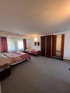 a hotel room with two beds and a tv at Hotel Begić in Sarajevo