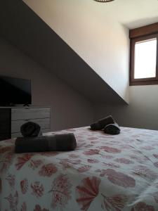 a bedroom with a bed with two pillows on it at Aldea Bricia 20 BC in Posada de Llanes