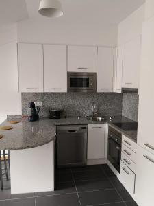 a kitchen with white cabinets and a counter top at Aldea Bricia 20 BC in Posada de Llanes