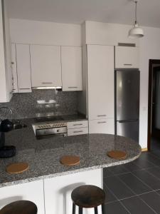a kitchen with a counter with a refrigerator and stools at Aldea Bricia 20 BC in Posada de Llanes