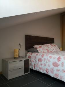 a bedroom with a bed with a wooden headboard and a night stand at Aldea Bricia 20 BC in Posada de Llanes