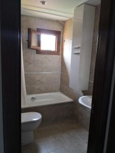 a bathroom with a toilet and a tub and a sink at Aldea Bricia 20 BC in Posada de Llanes