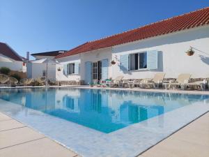 a swimming pool in front of a house at Villa Mariana Piscina Privada in Porto Covo