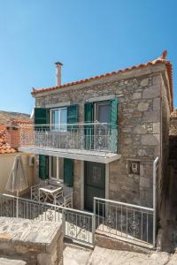 a stone house with a balcony and a patio at Traditional Stone House in Thános