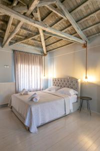 Un dormitorio con una cama grande en una habitación con techos de madera. en Traditional Stone House en Thános