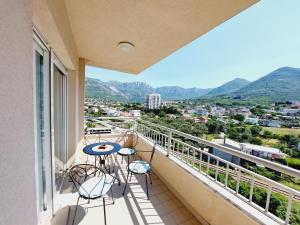 a balcony with a table and chairs and mountains at Aska Apartment in Bar