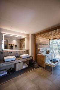 La salle de bains est pourvue de 2 lavabos et d'un grand miroir. dans l'établissement AhriaPura, à Sand in Taufers
