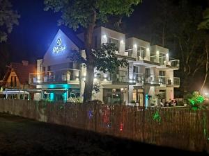 a large white building with lights on it at night at Majestique in Pobierowo