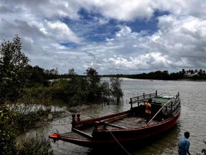 Łódź zakotwiczona jest na brzegu rzeki. w obiekcie Satrangi Homestay Sundarban w mieście Kākdwīp