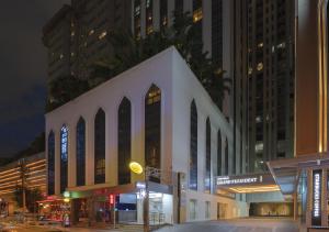 a white building on a city street at night at Grand President Bangkok in Bangkok