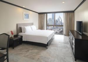 a hotel room with a bed and a television at Grand President Bangkok in Bangkok