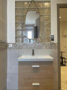 uma casa de banho com um lavatório e um espelho em L'Escale chambres privées chez l'habitant JFDL em Bonifacio