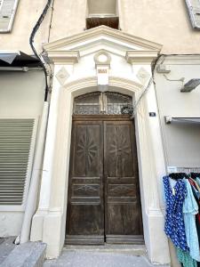 una grande porta in legno di un edificio di L'Escale chambres privées chez l'habitant JFDL a Bonifacio