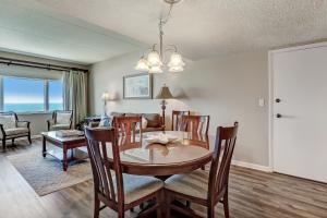 a dining room and living room with a table and chairs at Atlantic Ocean View Condo with Private Balcony and Access to Beachside Pool condo in Fernandina Beach