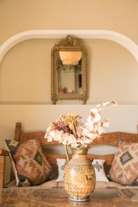 un jarrón con flores sobre una mesa con un espejo en Creta Vitalis, en Kalathas