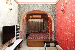 ein Schlafzimmer mit einem Bett und einer roten Wand in der Unterkunft Kavassu Heritage Haveli in Jhunjhunūn