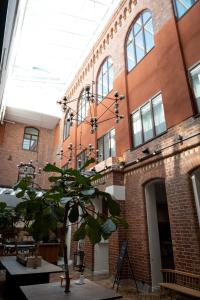 un gran edificio de ladrillo con un árbol delante de él en Elite Hotel Mimer en Umeå