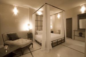 a bedroom with a canopy bed and a couch at Riad Joya in Marrakesh