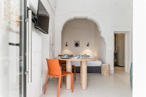 a dining room with a table and orange chairs at Petragrigia Vacation Suite in Ostuni