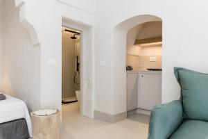 a living room with a couch and a kitchen at Petragrigia Vacation Suite in Ostuni