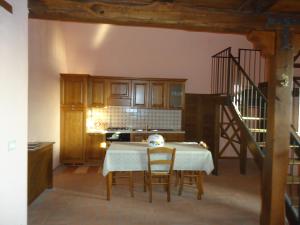 a kitchen with a table with chairs and a staircase at Residence Il Convento in SantʼAngelo a Fasanella