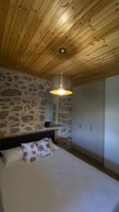 a bedroom with a white bed and a wooden ceiling at Six blossoms ! in Exanthia