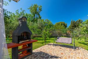a wood fired oven in a garden with a swing at Chill out in Marčana