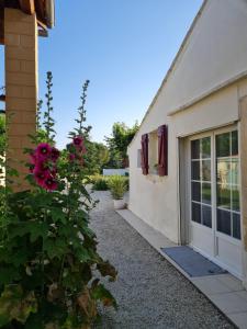 a building with a door and a flower bush at Maison de Campagne cosy in Pons