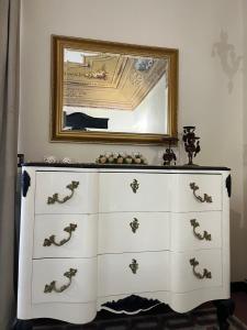 a white dresser with a mirror on a wall at La piazza è mia in Cefalù