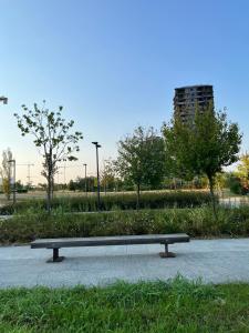 a bench sitting on a sidewalk in a park at Sweet Home in Milano smart district in Milan