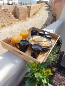 un vassoio con pancake e succo d'arancia su un tavolo di Dar Malika a El Jadida