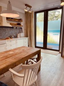 eine Küche mit einem Holztisch und Stühlen sowie einem Fenster in der Unterkunft Sea house Preila in Neringa