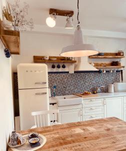 a kitchen with a table and a white refrigerator at Sea house Preila in Neringa