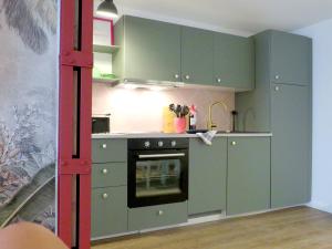 a kitchen with green cabinets and an oven at Casa del Mexikana in Kerpen