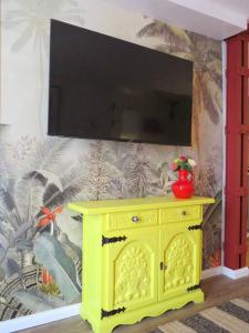 a yellow cabinet with a television on a wall at Casa del Mexikana in Kerpen