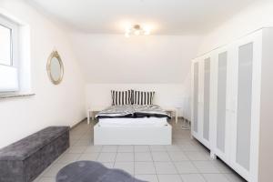 a white bedroom with a bed and a couch at Sonnendeck4 in Siegen