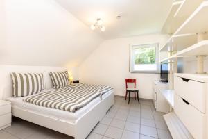 a white bedroom with a bed and a desk at Sonnendeck4 in Siegen