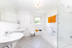 bagno bianco con vasca, lavandino e servizi igienici di Sonnendeck4 a Siegen