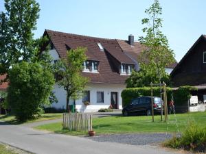 a house with a car parked in the driveway at Haus Fiegle in Kressbronn am Bodensee