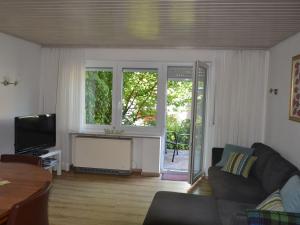 a living room with a couch and a television at Haus Fiegle in Kressbronn am Bodensee