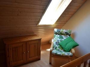 a attic room with a skylight and a chair at Haus Fiegle in Kressbronn am Bodensee