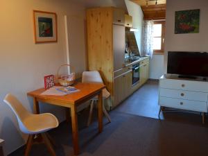 uma pequena cozinha com uma mesa de madeira e uma sala de jantar em Haus Fiegle em Kressbronn am Bodensee