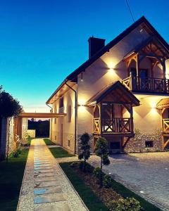 a large white building with a pathway in front of it at Bulwar Residence & Wellness in Kazimierz Dolny