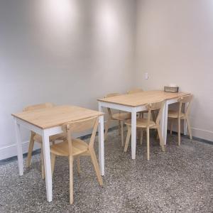 - deux tables et chaises en bois dans une pièce dans l'établissement TOMO B&B, à Taïtung